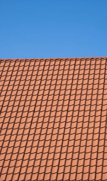 rotes wellblechprofildach auf einem modernen haus installiert. das dach aus wellblech. dach aus metallprofil wellenförmig. modernes dach aus metall. metalldächerung. - red tile stock-fotos und bilder