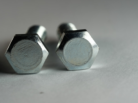 A closeup shot of lag screws on a gray surface