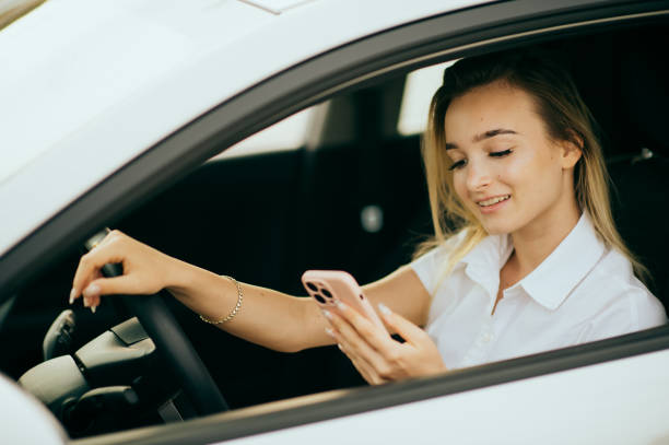 istock Young woman using phone in the car 1441190352