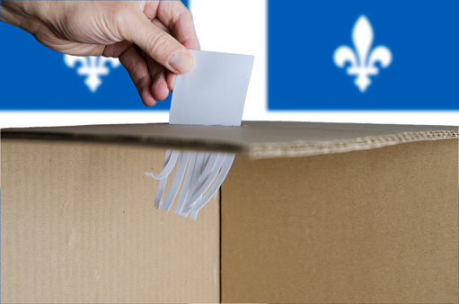 Voting card being shredded when inserted in ballot box on Quebec flag background. Shredded paper at the bottom of the box.