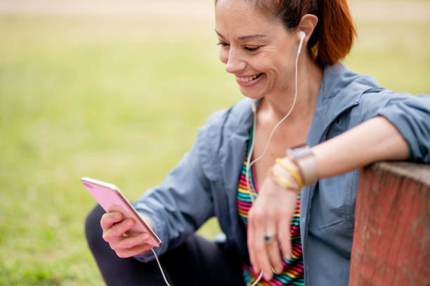 istock Woman using cell phone outdoors in a park after exercising 1441191680