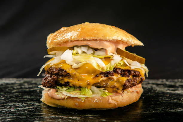 istock Closeup shot of a multi-layer hamburger on an isolated black background 1441191698