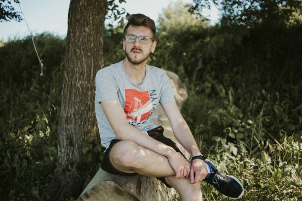istock Caucasian male sitting on a tree slog 1441191763