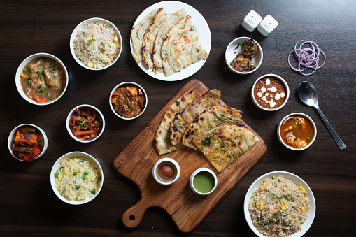 Click of variety of side dishes and food with sliced roti and onions kept on the table for taste...............
