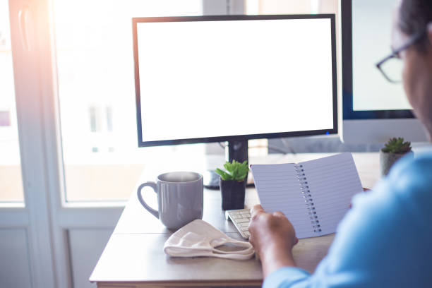 istock Back view of a male working on his computer with a cup of coffee 1441195053