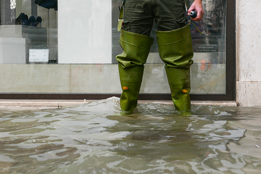Venice, Italy – November 13, 2019: After the great flood, you could only walk through Venice in high rubber boots. The water was up tothe knees that morning.