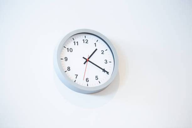 istock Low angle closeup view of a white clock on a white wall 1441195249
