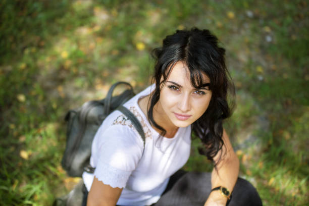 A beautiful Caucasian female sitting on a grass