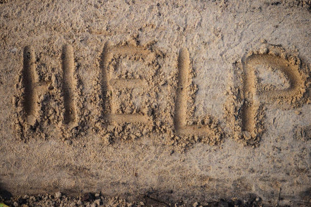 istock Help. Inscription in letters on sand. View from top. Appeal for assistance. 1441196826