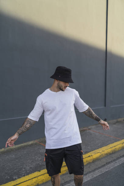 istock Young man with tattoos in a hat and casual style 1441197722