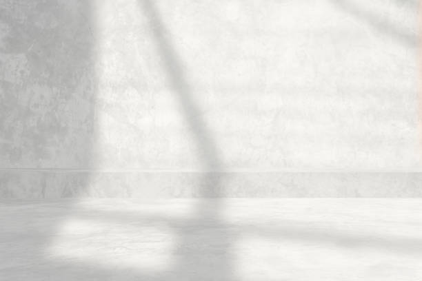 istock White Raw Concrete Room with Light Beam and Shadow from the Window Background. 1441198232