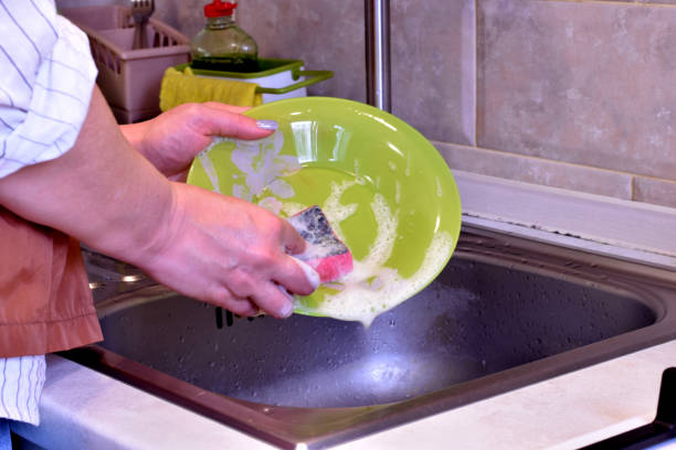 istock A woman washes a dish with a washcloth. 1441199222