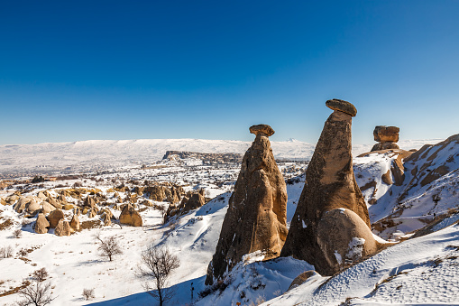 Snowy winter scene at the three Beauties. Rocky hills in Devrent valley Cappadocia, Nevsehir, Turkey.
