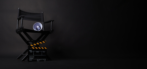 Director chair and Clapper board and megaphone on black blackground.