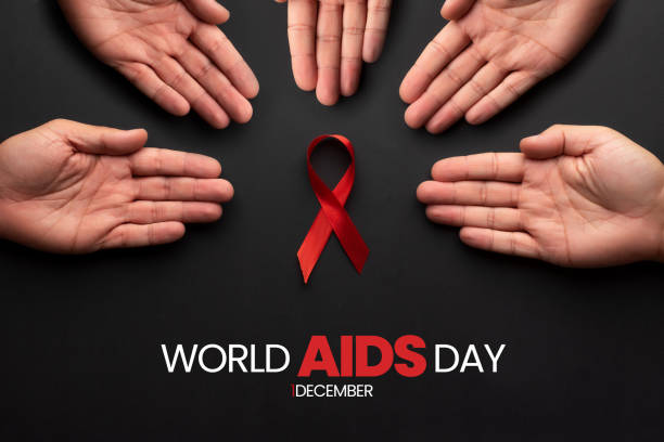 zestaw rąk otaczających czerwoną wstążkę symbolizującą światowy dzień aids. 1 grudnia, dzień walki z chorobą hiv. wspieranie chorych - world aids day zdjęcia i obrazy z banku zdjęć