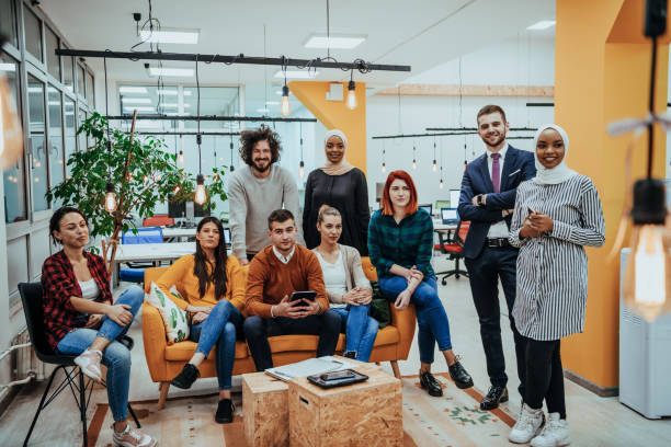 istock Group of multi-ethnic colleagues working on desktop computers, laptop and sharing their ideas in a modern office space.Young influencers work on online marketing projects. 1441210734