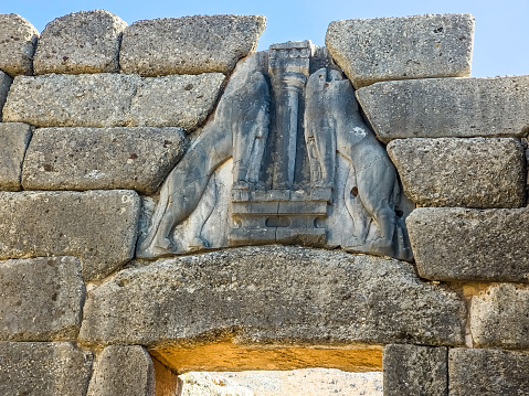 The confronting lionesses posing on both sides of a pillar above the lintel of the Lion Gate at the archaeological site of Mycenae near Mykines in Argolis, north-eastern Peloponnese, Greece