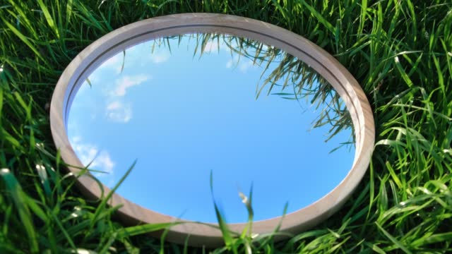 Cloudy Blue Sky Reflection in Round Wood Mirror on Summer Field with Green Grass. Nature Concept. Earth Day. Save Environment. Peace. Ecology Protection. Climate Change, Global Warming Effect Problem