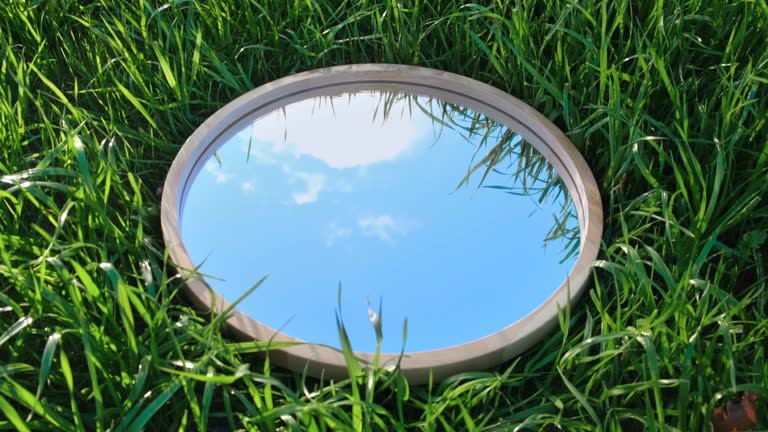 Cloudy Blue Sky Reflection in Round Wood Mirror on Summer Field with Green Grass. Nature Concept. Earth Day. Save Environment. Peace. Ecology Protection. Climate Change, Global Warming Effect Problem