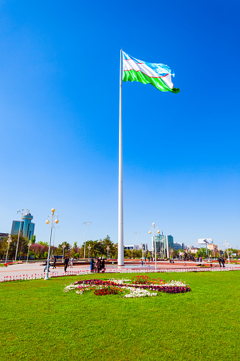Tashkent, Uzbekistan - April 11, 2021: National Flag of Uzbekistan at the Bunyodkor or Friendship of Peoples square in Tashkent city, Uzbekistan