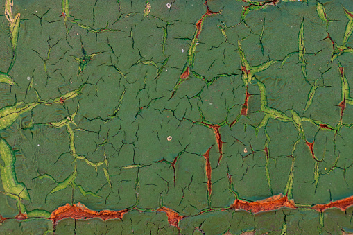 Green and red close up of cracked paint