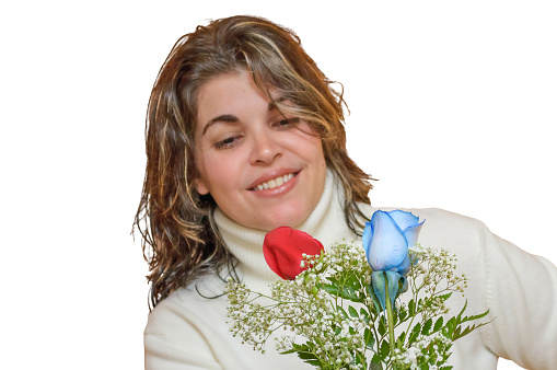Close-up portrait of a charming young woman holding flowers