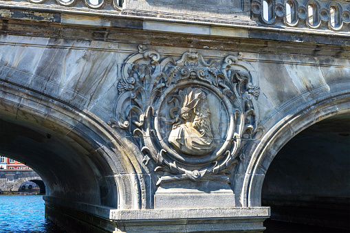 Bas-relief in the form of a profile of a man with a beard in an oval close-up on a bridge in Copenhagen, Denmark. Decor elements of the bridge in Copenhagen. City decorations.