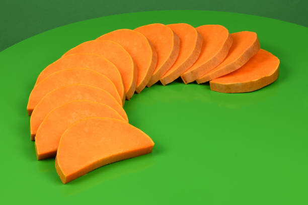 Ripe sliced Butternut squash (Cucurbita moschata). Vegetable on geen background. High resolution photo. Full depth of field.