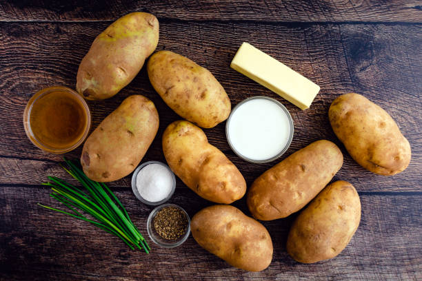 Mashed Potato Ingredients on a Rustic Wood Table Russet potatoes, cream, butter, and other ingredients for mashed potato side dish Russet Potato stock pictures, royalty-free photos & images