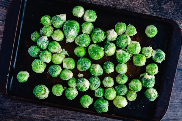 Brussels sprouts covered in garlic butter and spread on a baking sheet