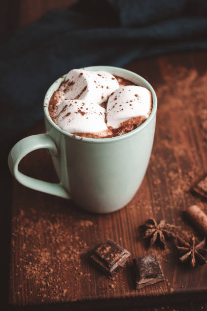 istock Hot chocolate drink with marshmallow in a cup on wooden board, dark background 1441230971