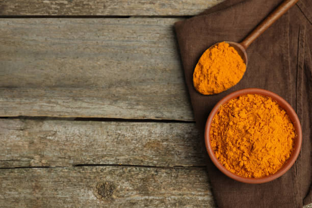 istock Bowl and spoon with saffron powder on wooden table, top view. Space for text 1441235140