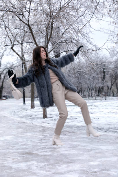 Two women embrace on the embankment near a frozen river in winter