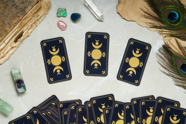 istock Tarot cards, peacock feathers, gemstones and old book on light table, flat lay. Reverse side 1441236718