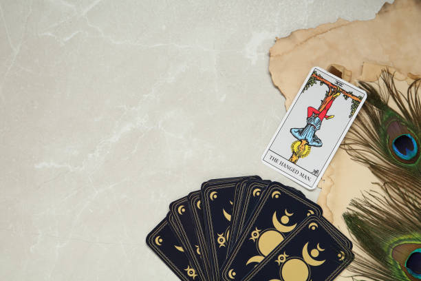 istock The Hanged Man and other tarot cards near peacock feathers on light table, flat lay. Space for text 1441237205
