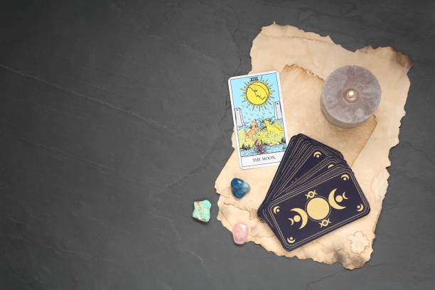 istock The Moon with other tarot cards, candle and gemstones on black table, flat lay. Space for text 1441237390