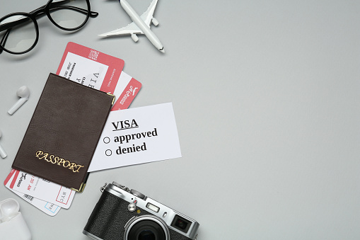Flat lay composition with passport, toy plane and tickets on light grey background, space for text. Visa receiving