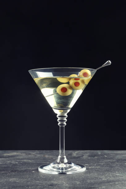 istock Martini cocktail with olives on grey table against dark background 1441239943