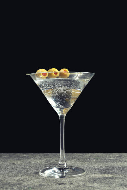 istock Martini cocktail with olives on grey table against dark background 1441240078