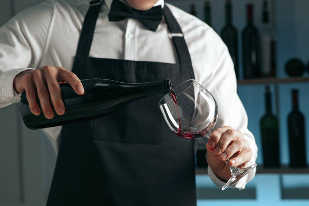 istock Bartender pouring wine into glass in restaurant, closeup 1441240084