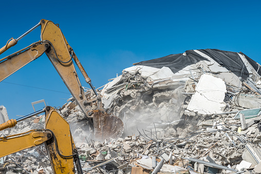 Excavators rapidly removing debris from a collapsed building.