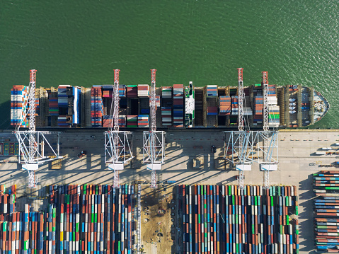 Aerial view of Industrial shipping port. View from drone. Loading containers on the ship, cranes load containers.