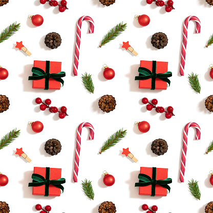 Christmas decorations seamless pattern on a white background. Gifts, fir branches, berries and lollipops. Winter concept. Top view, flat lay. Happy new year.