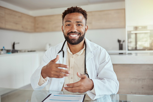 Happy medical doctor, home desk in online healthcare and portrait of black man smile in digital consultation. Physician on virtual telehealth appointment, tech service and talking on video call pov