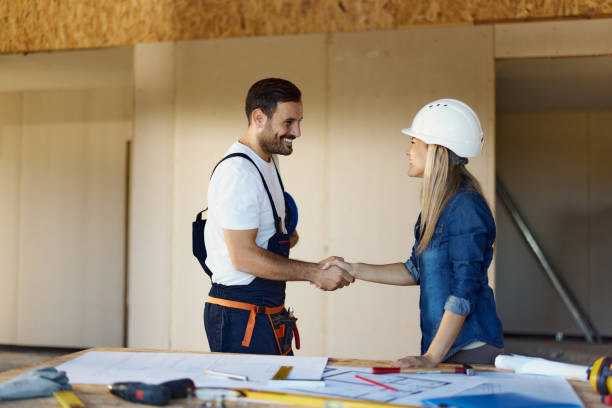istock Happy worker greeting female inspector at construction site. 1441249160