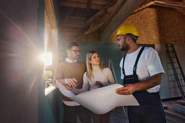 istock Couple talking about blueprints with manual worker at construction site. 1441249271