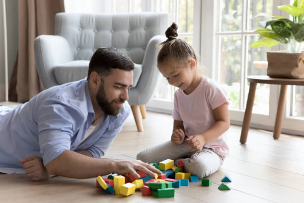 istock Young daddy and cute little daughter build together with blocks 1441251676