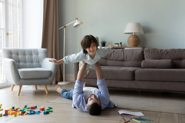 istock Young dad lift on stretched arms cute little son 1441251679