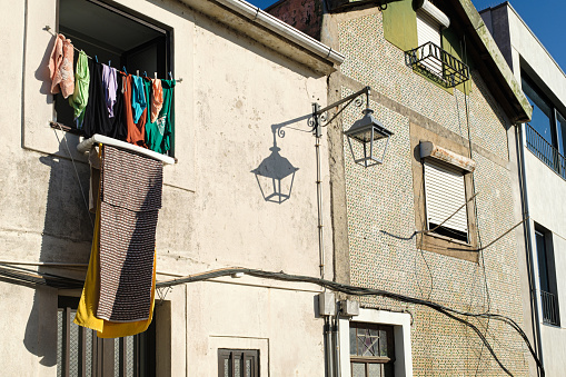 Clothes drying outside a window on a tiled brick wall facade in Porto, Portugal on a typical scene