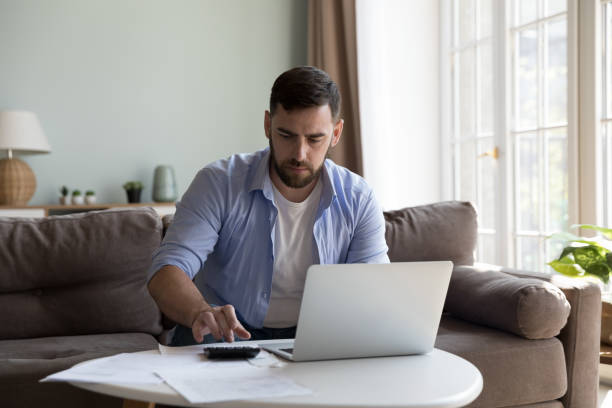 istock Man pay taxes, bills online using e-bank on laptop 1441252181
